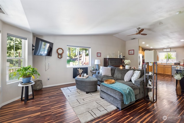 living room with a healthy amount of sunlight, dark hardwood / wood-style flooring, and vaulted ceiling