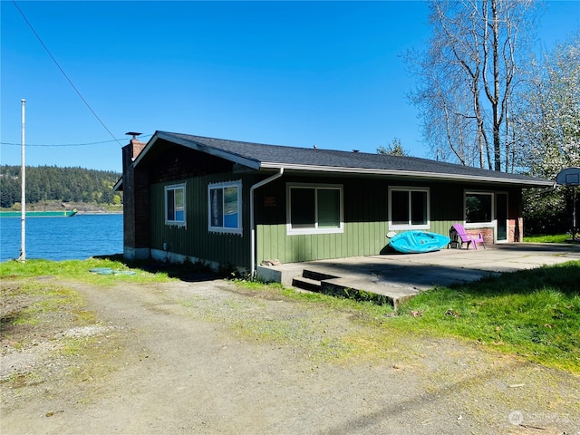 view of front of property with a patio area and a water view