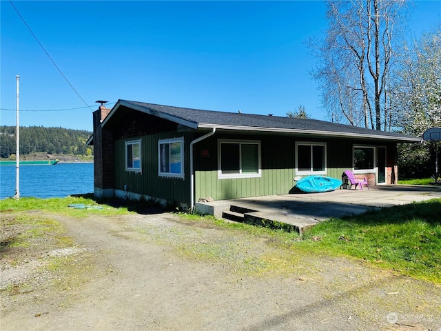 1769 SW Bay St, Port Orchard, WA 98366 - view of front of home featuring a chimney, a patio, and a water view