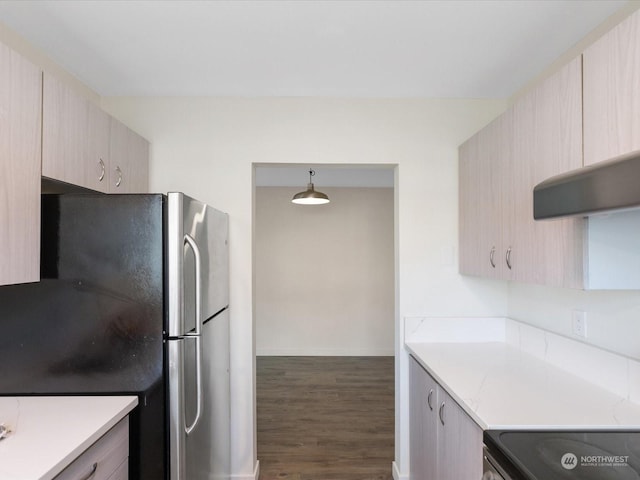 kitchen featuring light brown cabinets, stainless steel appliances, dark hardwood / wood-style floors, and hanging light fixtures