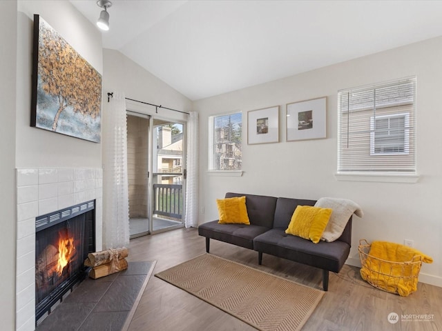 living room with a fireplace, hardwood / wood-style floors, and lofted ceiling