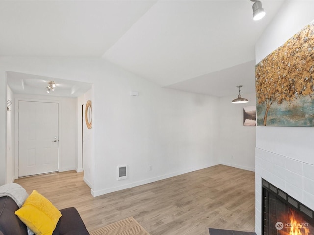 unfurnished living room with light hardwood / wood-style floors and vaulted ceiling