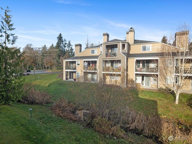 rear view of property featuring a lawn