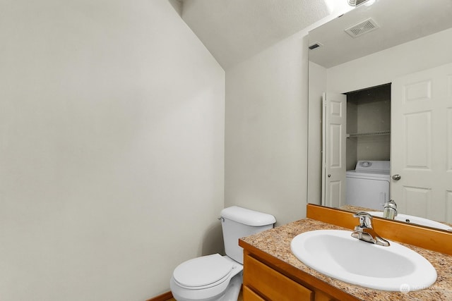 bathroom featuring vanity, toilet, washer / dryer, and lofted ceiling