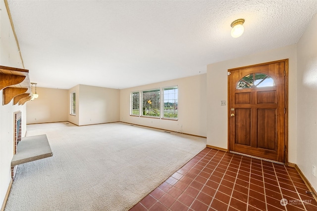 carpeted foyer with a fireplace and a textured ceiling