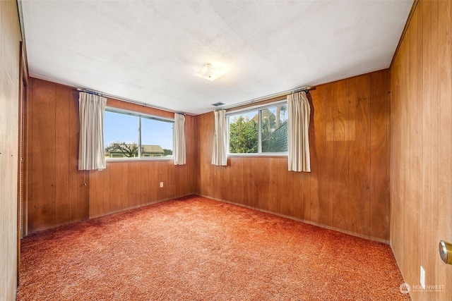 carpeted empty room with wooden walls