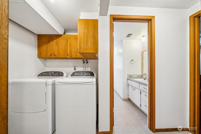 laundry area with sink, cabinets, and washing machine and clothes dryer