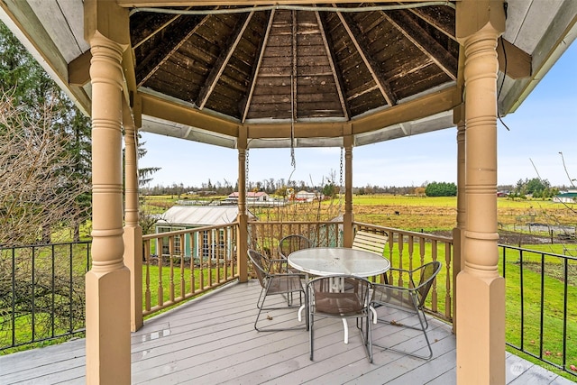 wooden deck featuring a rural view, a yard, and a gazebo