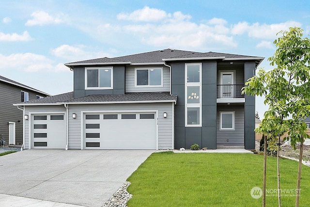 prairie-style home with a balcony, a garage, and a front lawn