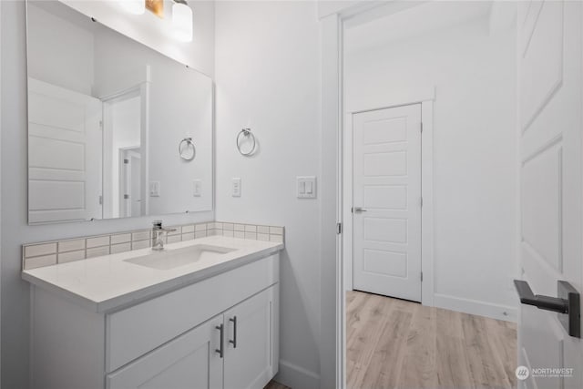 bathroom with decorative backsplash, vanity, and hardwood / wood-style flooring