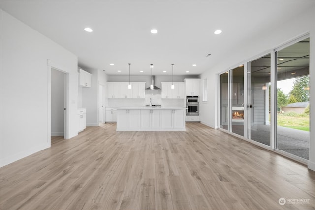 unfurnished living room featuring light wood-type flooring and sink