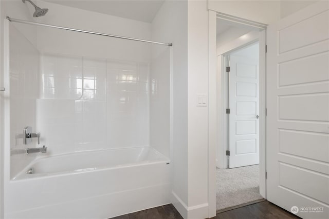 bathroom with hardwood / wood-style flooring and shower / washtub combination