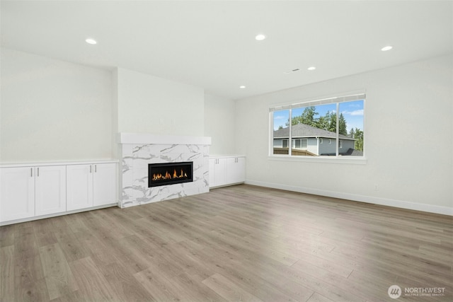 6202 229th Ave E, Buckley, WA 98321 - unfurnished living room with light wood-style flooring, a high end fireplace, and recessed lighting