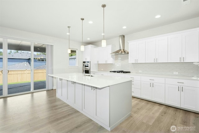 6202 229th Ave E, Buckley, WA 98321 - kitchen with wall chimney exhaust hood, light wood-style flooring, backsplash, light countertops, and recessed lighting
