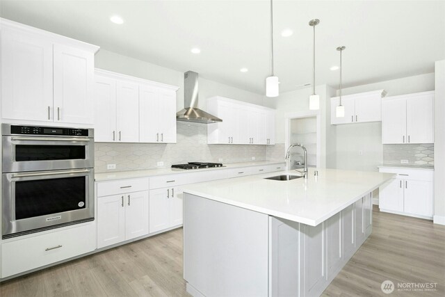 6202 229th Ave E, Buckley, WA 98321 - kitchen with wall chimney range hood, appliances with stainless steel finishes, backsplash, light wood-style floors, and light countertops