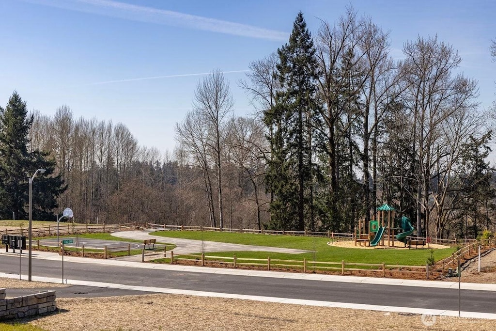 exterior space featuring playground community, a lawn, and fence