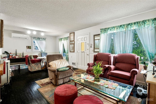 living room featuring dark hardwood / wood-style flooring, an AC wall unit, and a textured ceiling