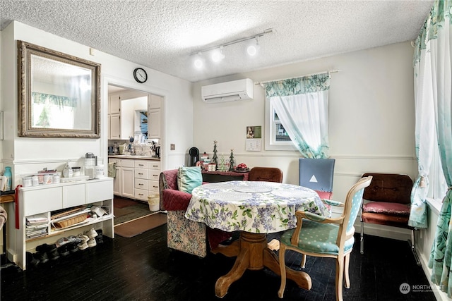 dining room featuring a textured ceiling, dark hardwood / wood-style floors, track lighting, and a wall mounted AC