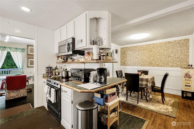 kitchen with dark hardwood / wood-style floors, black electric range oven, white cabinetry, and ornamental molding