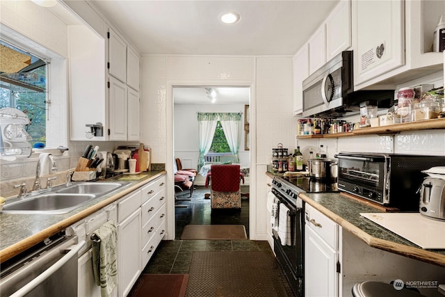 kitchen featuring backsplash, sink, white cabinets, and appliances with stainless steel finishes