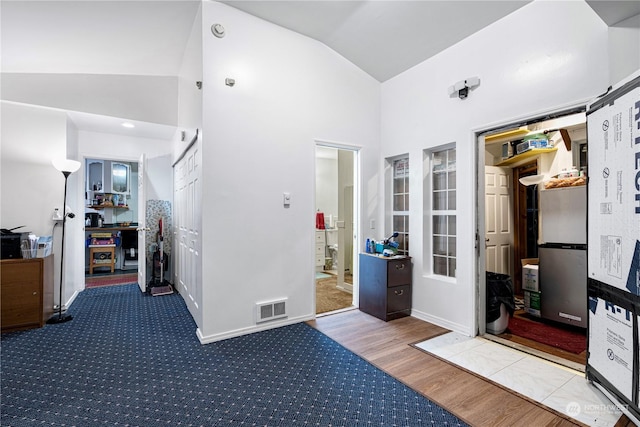 interior space featuring high vaulted ceiling and light hardwood / wood-style flooring