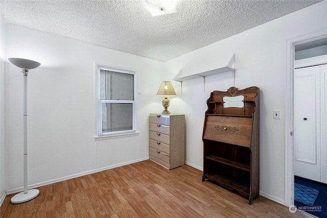 bedroom with a textured ceiling and light hardwood / wood-style floors