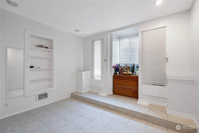 tiled spare room with built in shelves