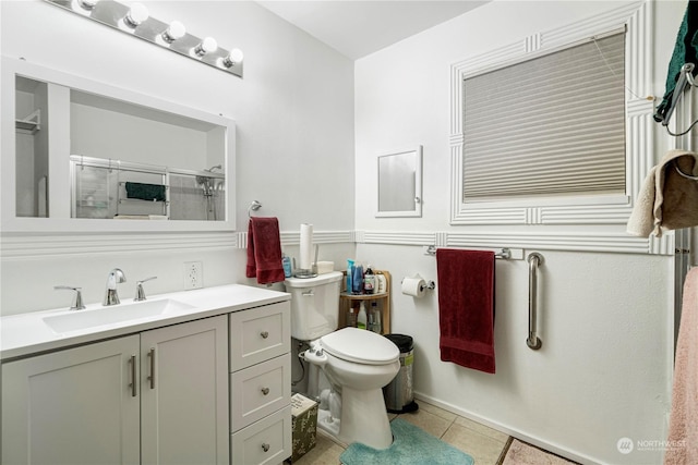 bathroom featuring toilet, a shower, vanity, and tile patterned floors