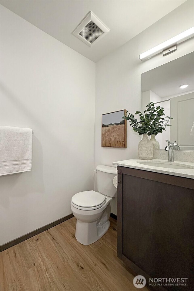 bathroom featuring hardwood / wood-style flooring, vanity, and toilet