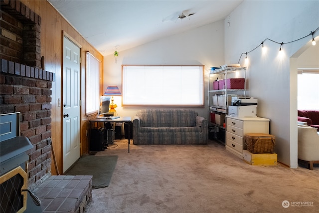 carpeted living room with plenty of natural light, lofted ceiling, and a wood stove