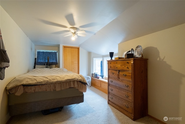 carpeted bedroom featuring ceiling fan, lofted ceiling, and a closet