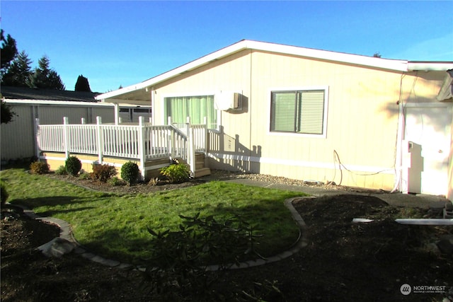 back of property featuring a lawn and a deck