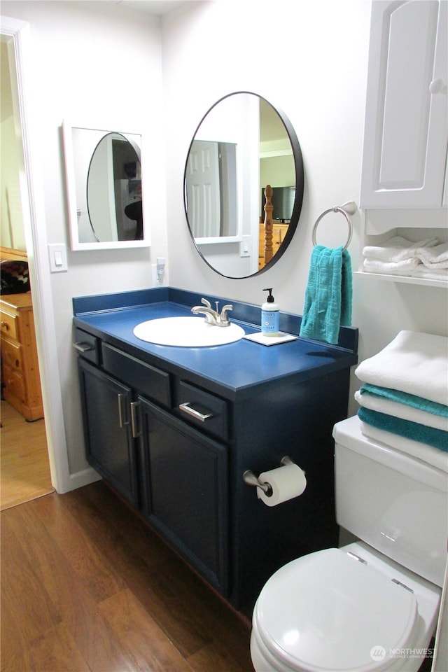 bathroom with hardwood / wood-style floors, vanity, and toilet