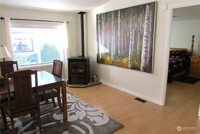 office area featuring light wood-type flooring and a wood stove