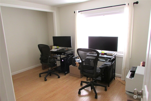 office with light hardwood / wood-style flooring and plenty of natural light