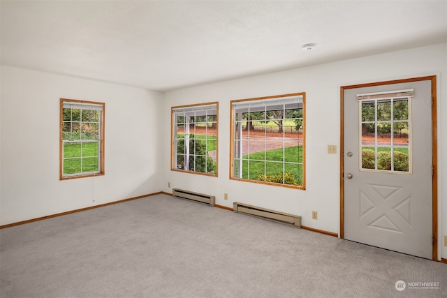 carpeted spare room with baseboard heating and plenty of natural light