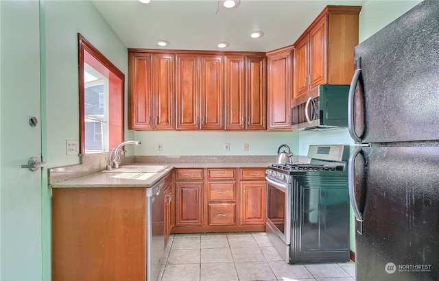 kitchen with appliances with stainless steel finishes, light tile patterned floors, and sink