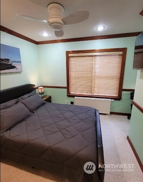 unfurnished bedroom featuring ceiling fan, radiator heating unit, and crown molding