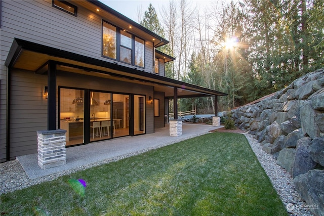 rear view of property with a yard and a patio