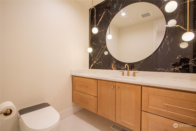 bathroom with vanity, backsplash, tile patterned flooring, and toilet