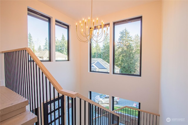 staircase with a notable chandelier