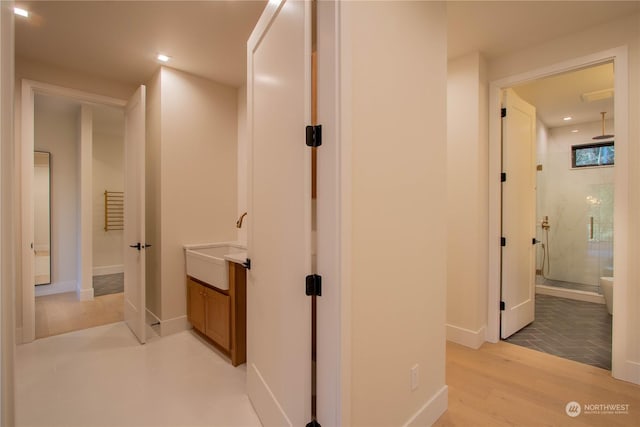 corridor featuring sink and light hardwood / wood-style floors