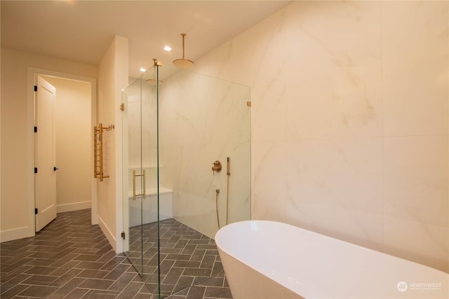 bathroom featuring independent shower and bath and tile walls