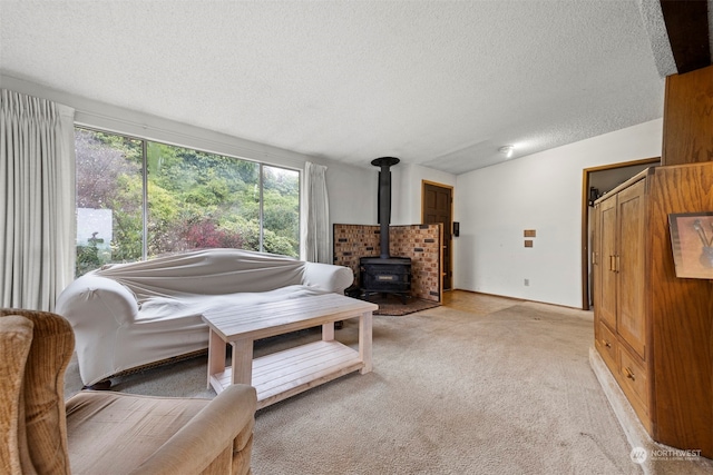 living room with a wood stove, light carpet, and a textured ceiling