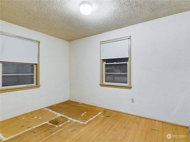 empty room featuring wood-type flooring and a textured ceiling