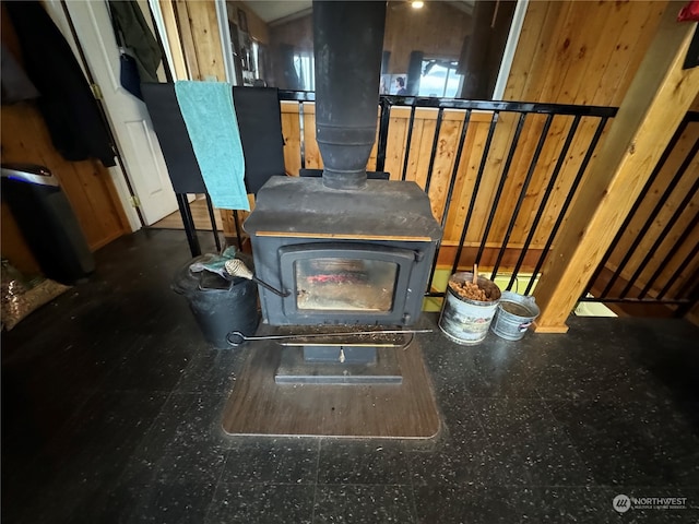 interior details featuring a wood stove and wood walls