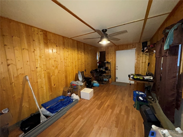 miscellaneous room with hardwood / wood-style flooring, ceiling fan, and wood walls