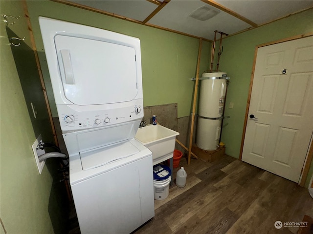 clothes washing area with sink, stacked washing maching and dryer, dark wood-type flooring, and water heater