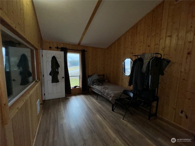 sitting room featuring wood-type flooring, wooden walls, and lofted ceiling