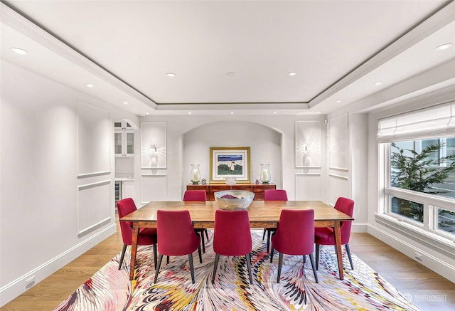 dining area featuring a tray ceiling and light hardwood / wood-style floors